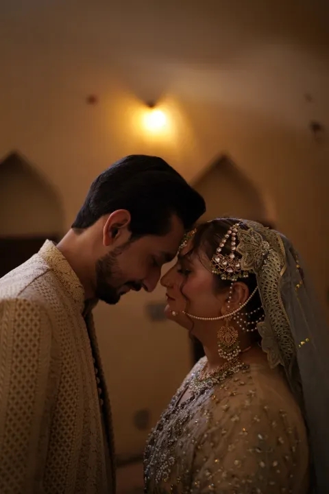 A bride and groom sharing an intimate moment with foreheads touching, captured by AM Productions.